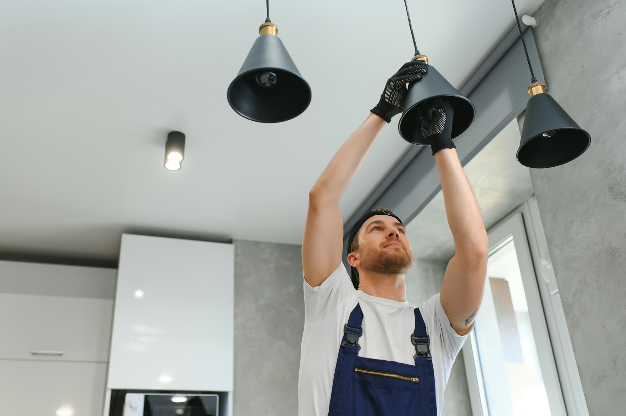 a-male-electrician-changes-the-light-bulbs-in-the-ceiling-light-men-s-household-duties-.jpg